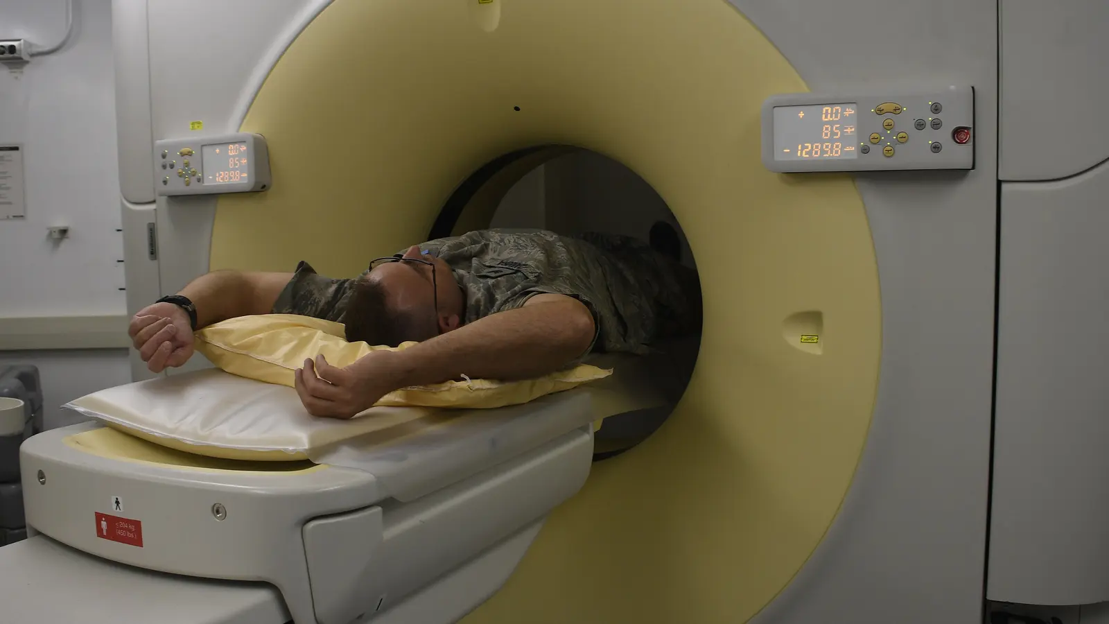A patient lying on the table of a CT scanner as the scan begins