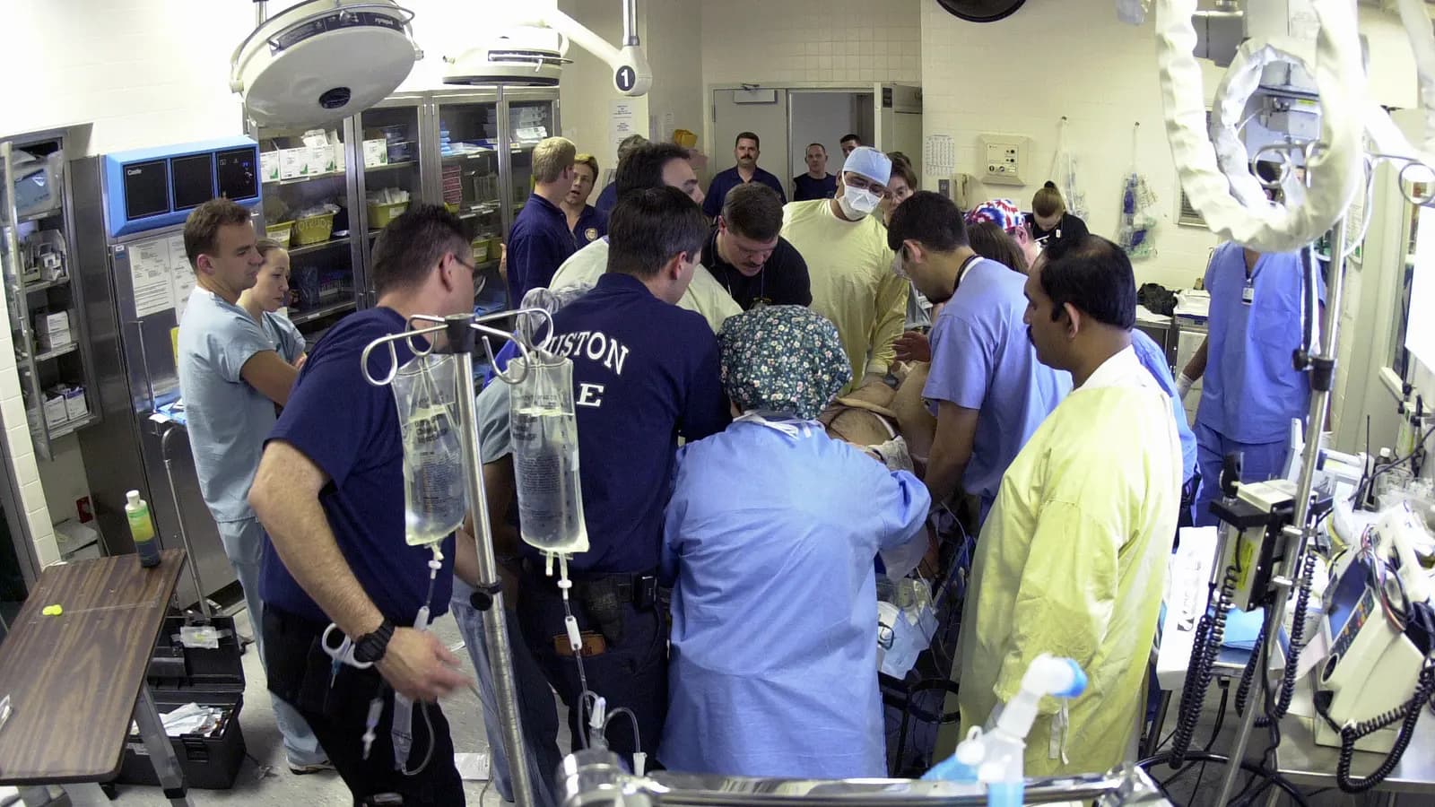 A large medical team working together around a patient in a hospital trauma bay