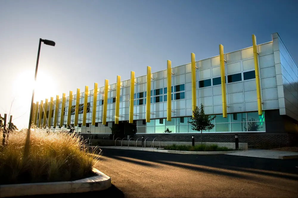 Exterior daytime view of the Charles Sturt University Orange campus building (Orange, NSW, Australia) — modern facade with distinctive yellow vertical fins and clear sky.